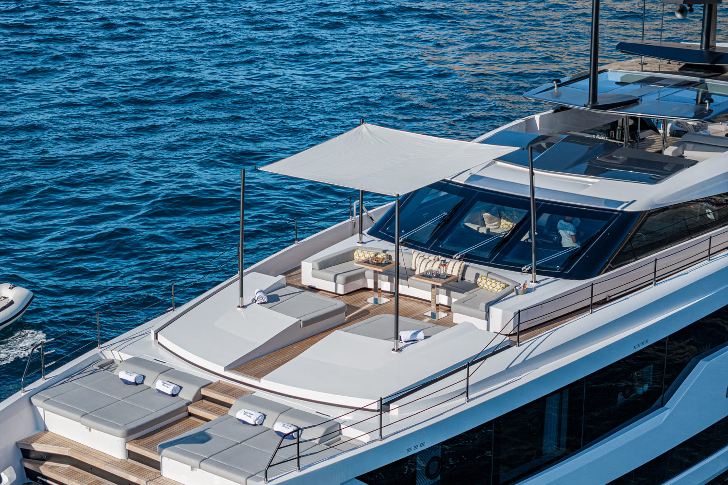 Aerial photograph of a yacht cruising near Antibes, with the stunning French Riviera coastline in the background.