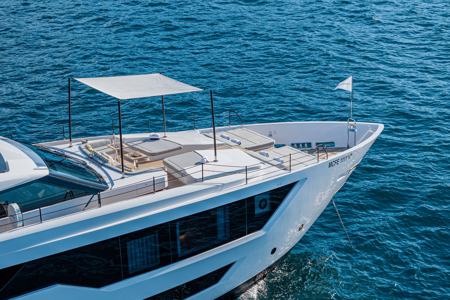 Aerial view of a yacht cruising near Monaco, with the Mediterranean Sea and coastline in the background.