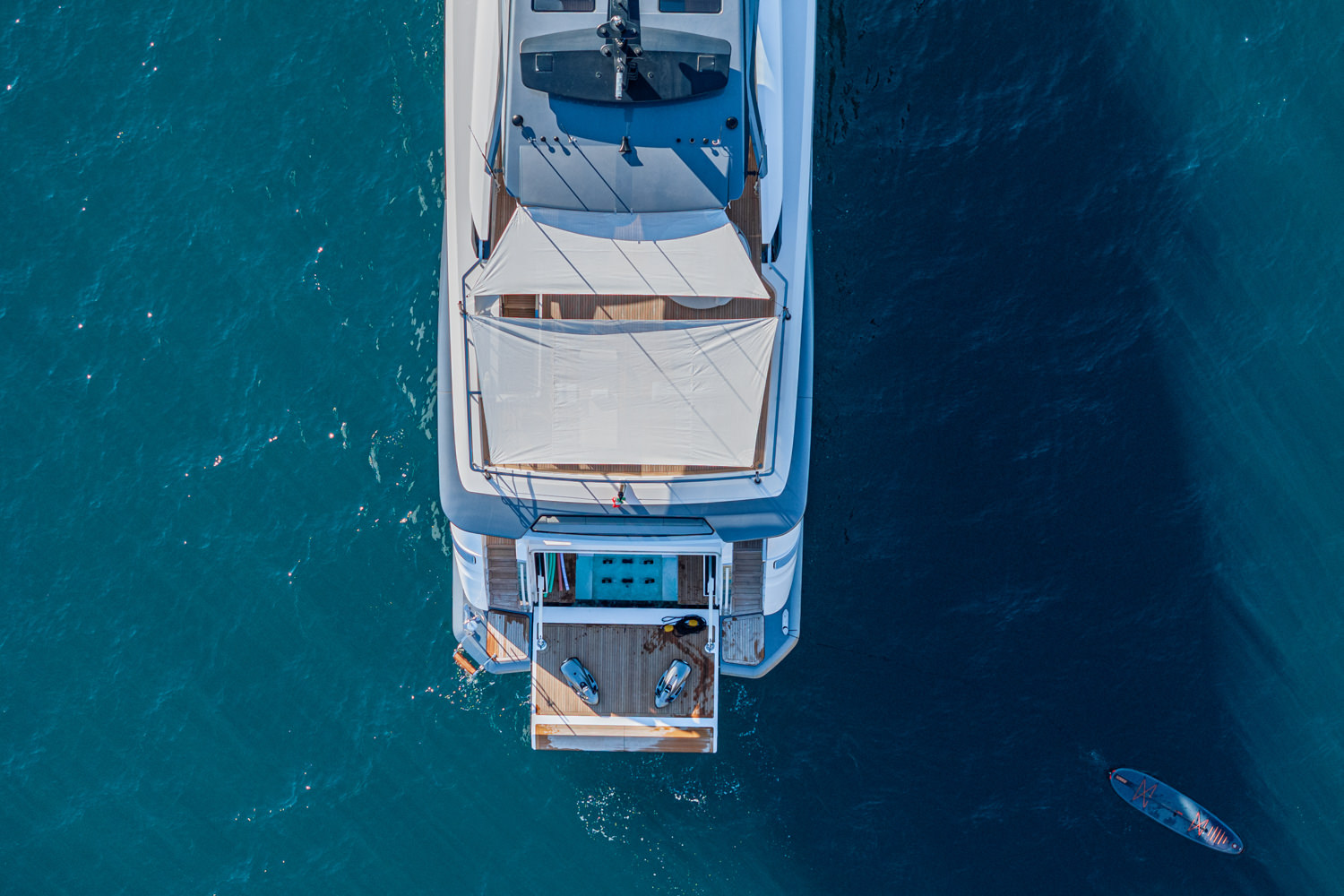 Aerial photograph of a yacht cruising near Nice, with the beautiful Mediterranean coastline in the background.
