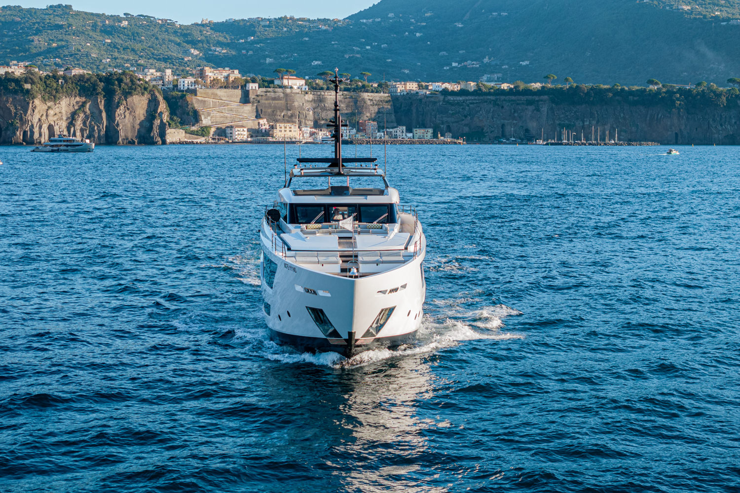 Aerial view of a yacht cruising near Cannes, with the scenic Mediterranean coastline in the background.