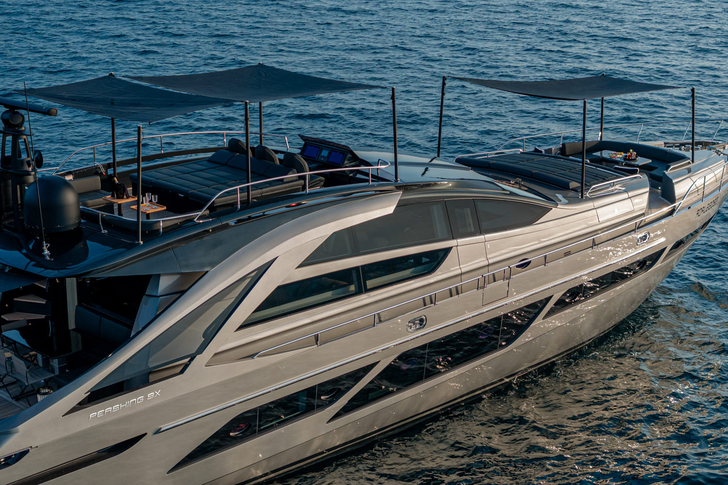 Aerial photograph of a yacht cruising near Cannes, with the beautiful Mediterranean coastline in the background.