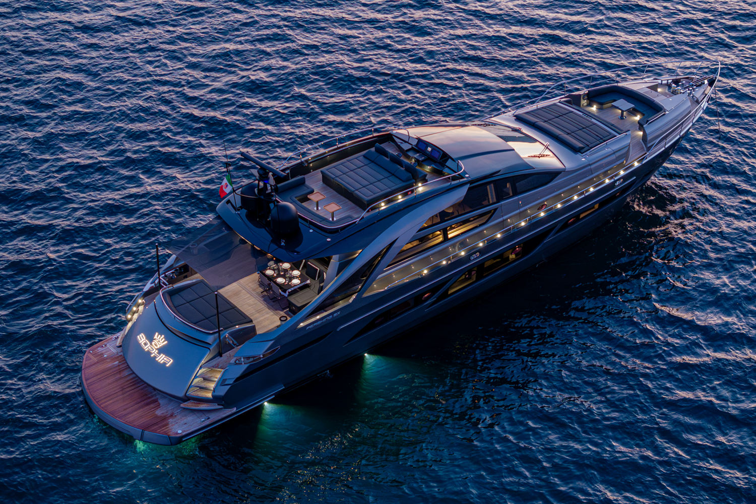 Aerial view of a yacht cruising near Saint-Tropez, with the Mediterranean coastline in the background.