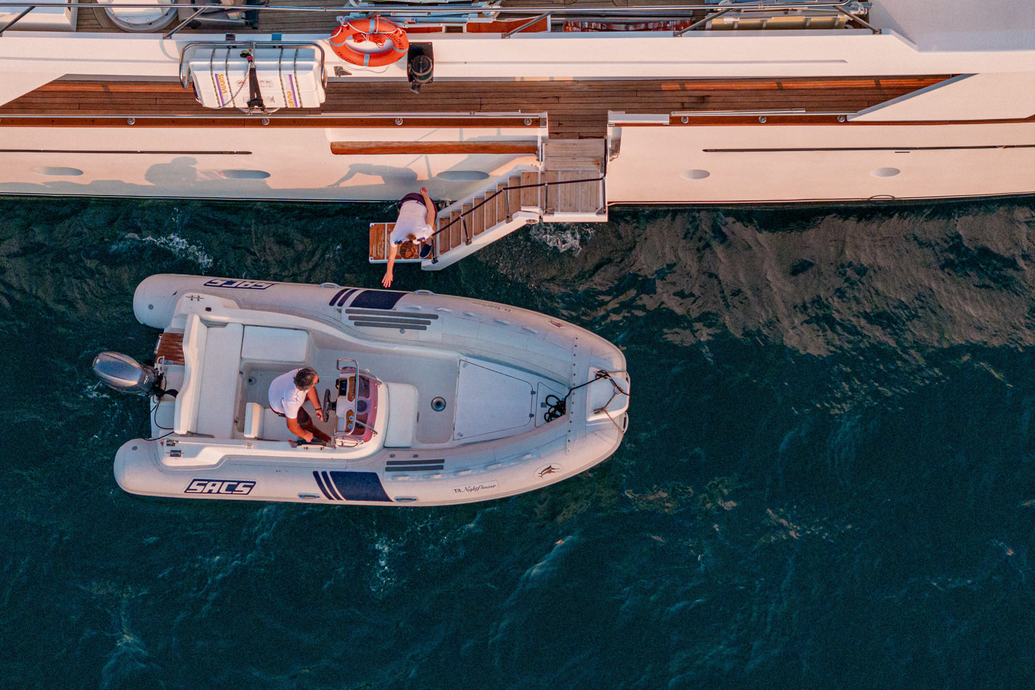 Aerial photograph of a yacht cruising near Nice, with the Mediterranean coastline and turquoise waters in the background.
