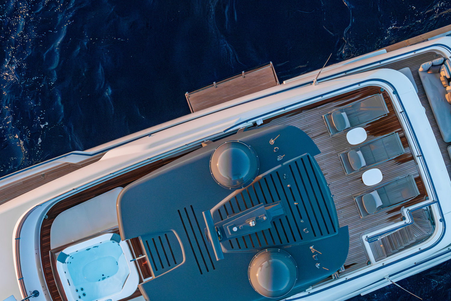 Aerial view of a yacht cruising along the scenic coast of Capri, with the island's iconic cliffs in the background.