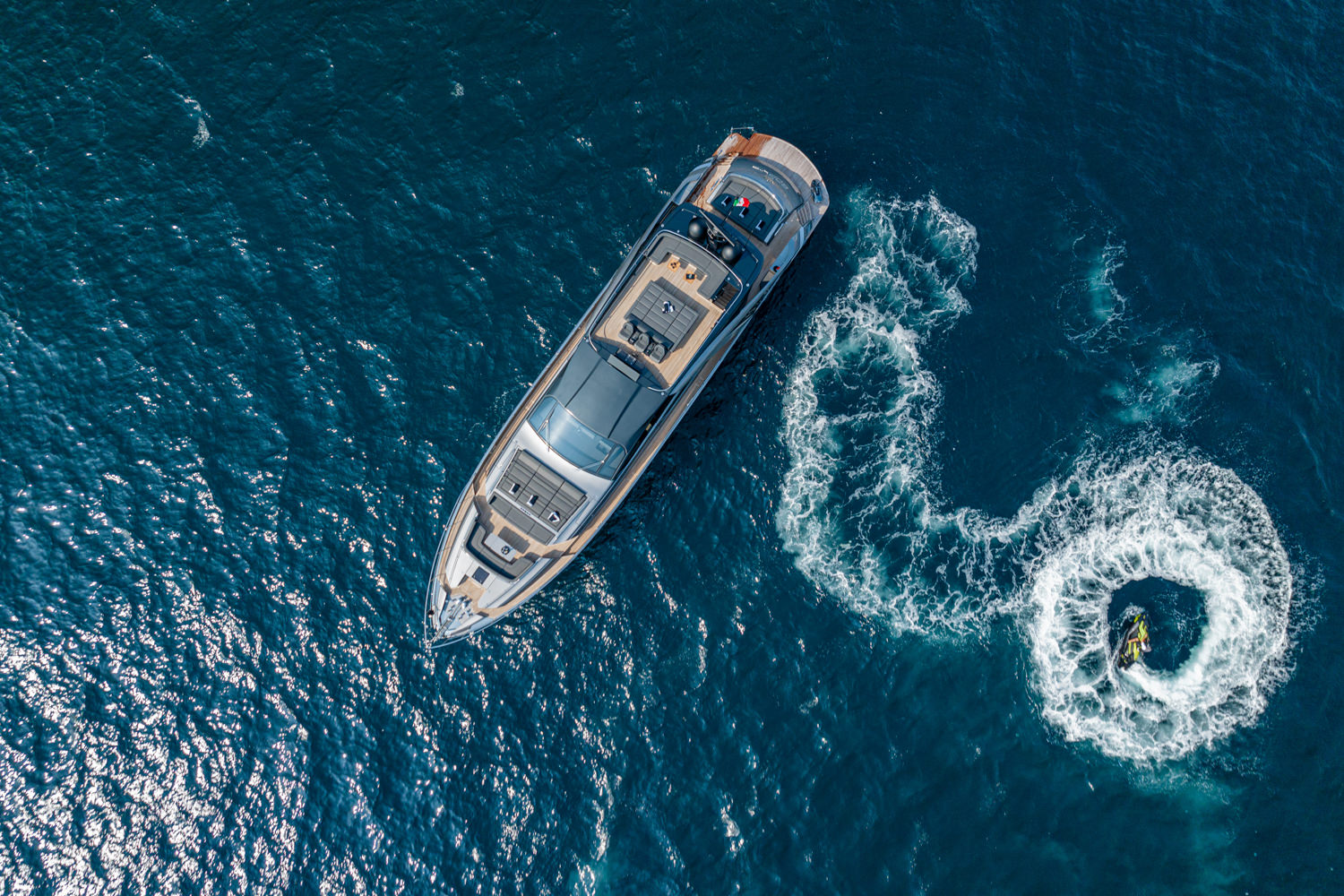 Aerial view of a yacht cruising near Antibes, with the Mediterranean coastline in the background.