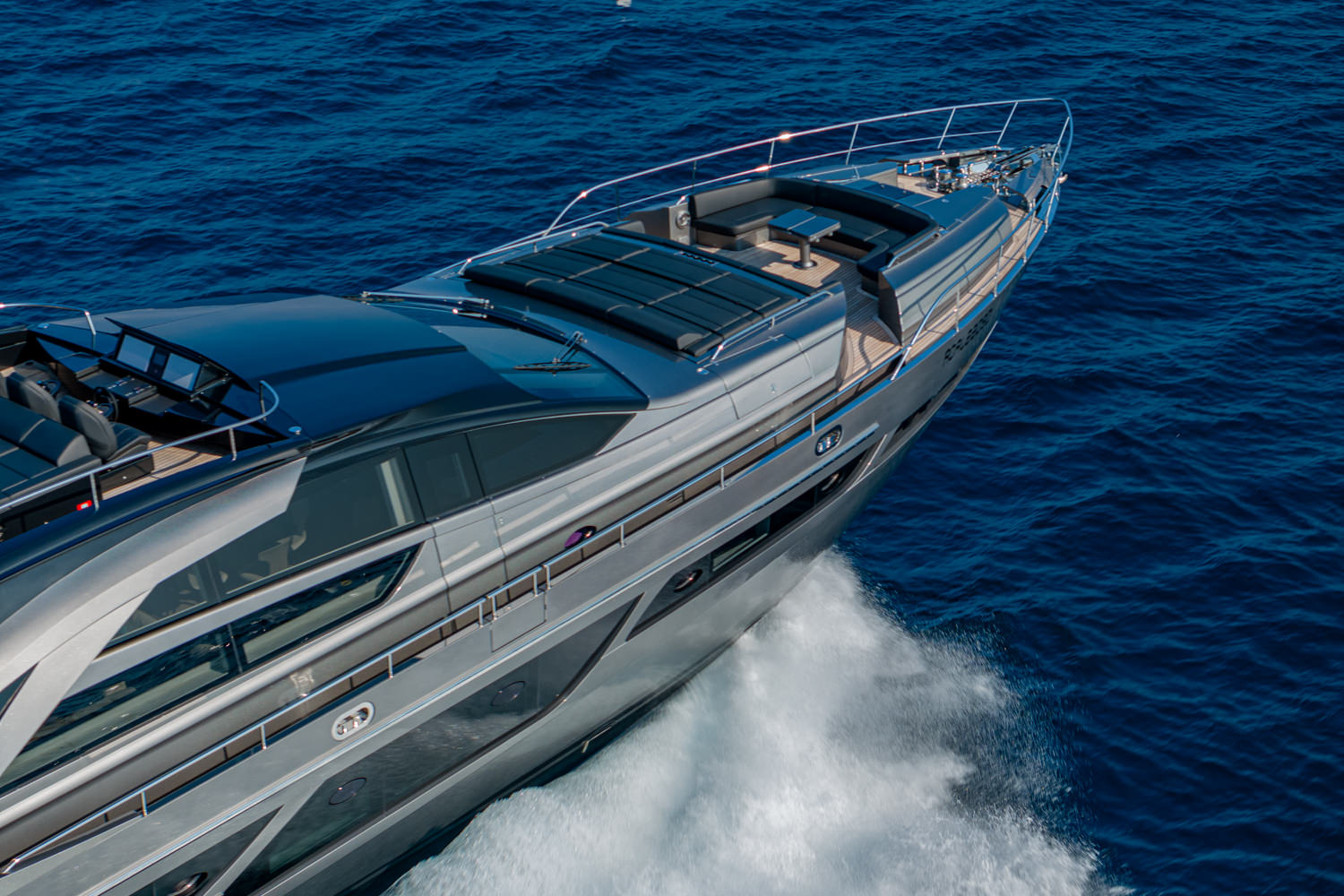 Aerial view of a yacht cruising near Nice, with the Mediterranean coastline and clear blue waters in the background.