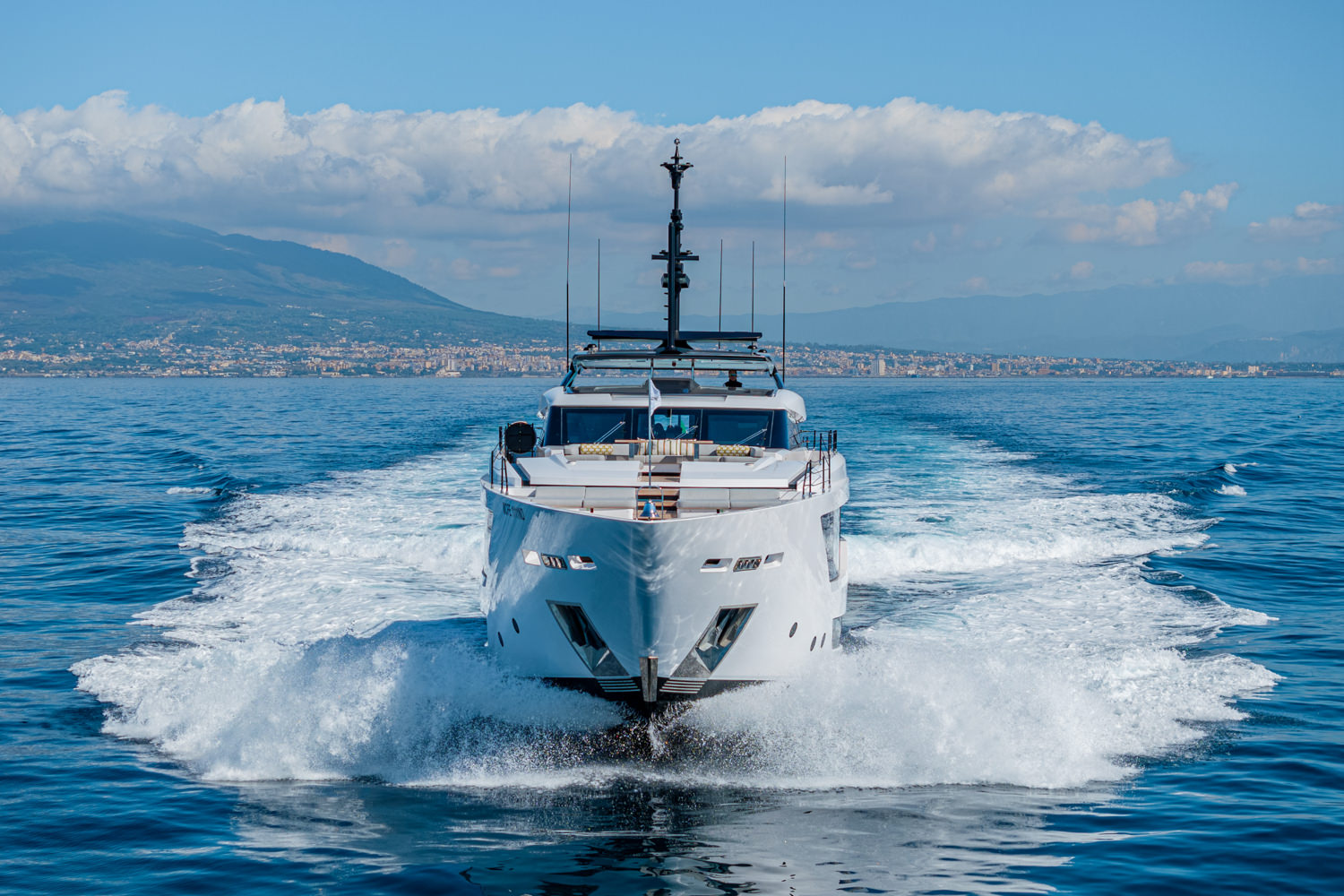 Aerial view of a yacht anchored in the Mediterranean near Monaco, with clear turquoise waters below.
