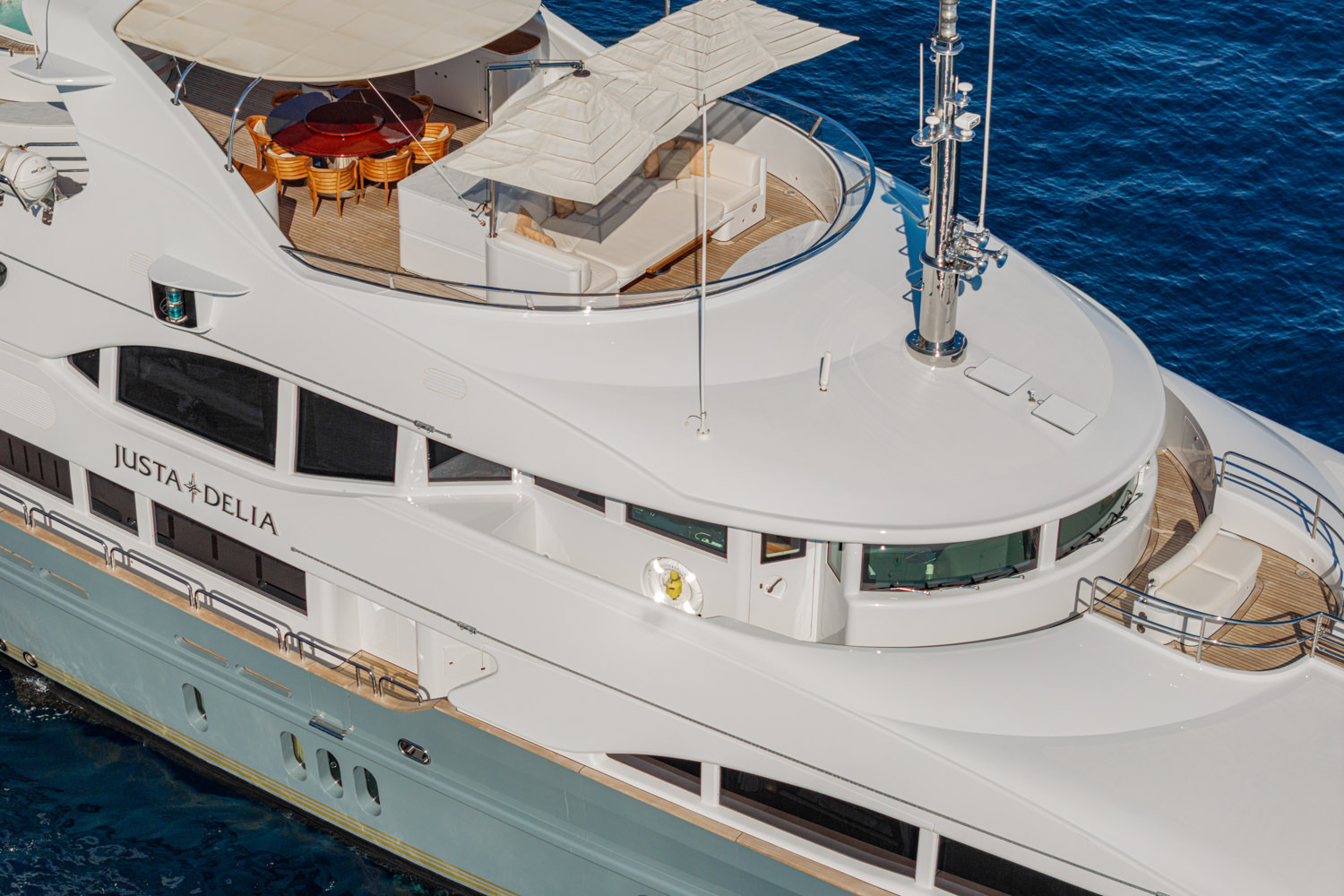 Drone photograph of a luxury yacht sailing near Imperia, with the Mediterranean coastline in the background.