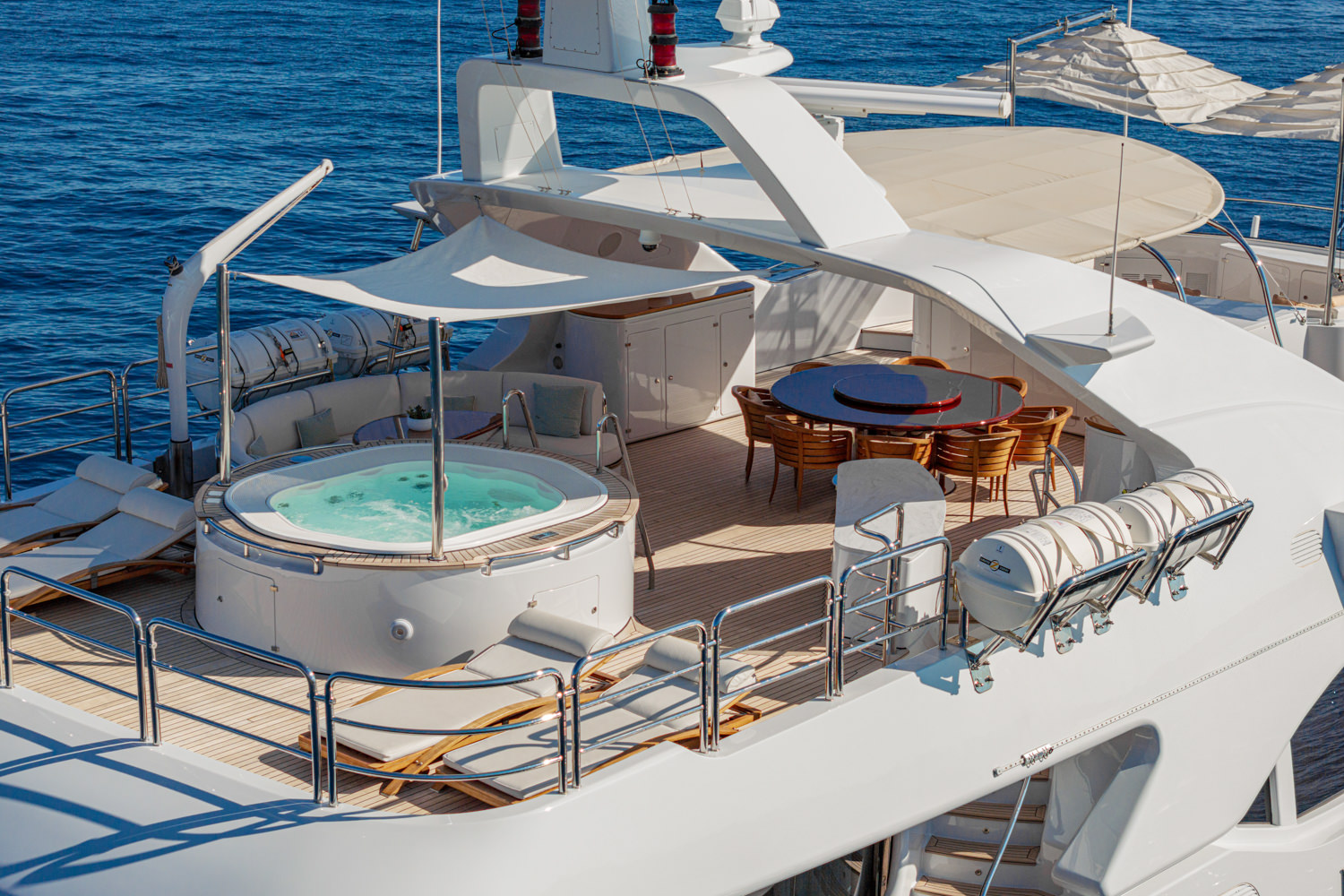 Aerial shot of a yacht cruising near Monaco, with the Mediterranean Sea and coastline in the background.