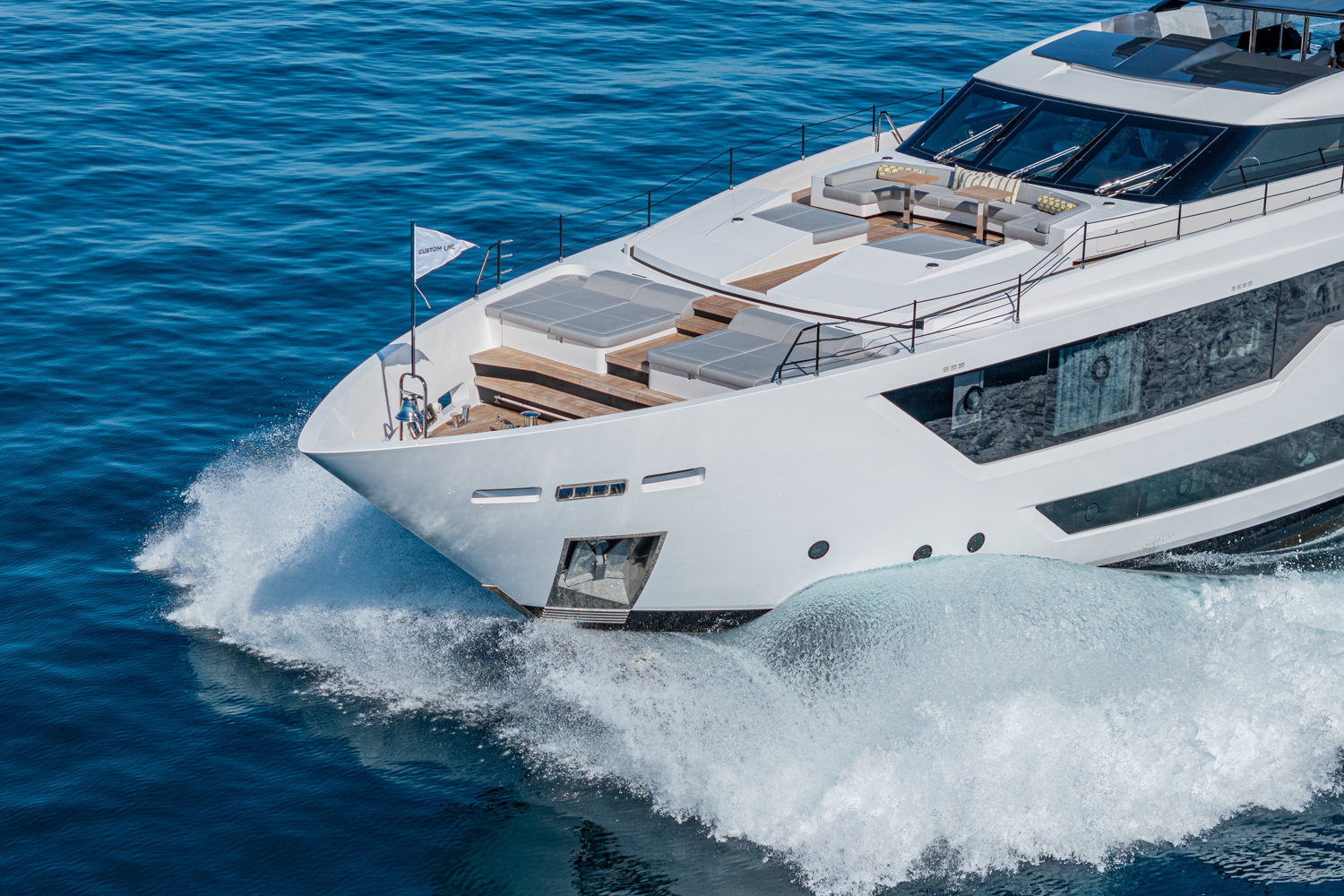 Aerial shot of a luxury yacht cruising near Cannes, with the picturesque French Riviera coastline in the background.