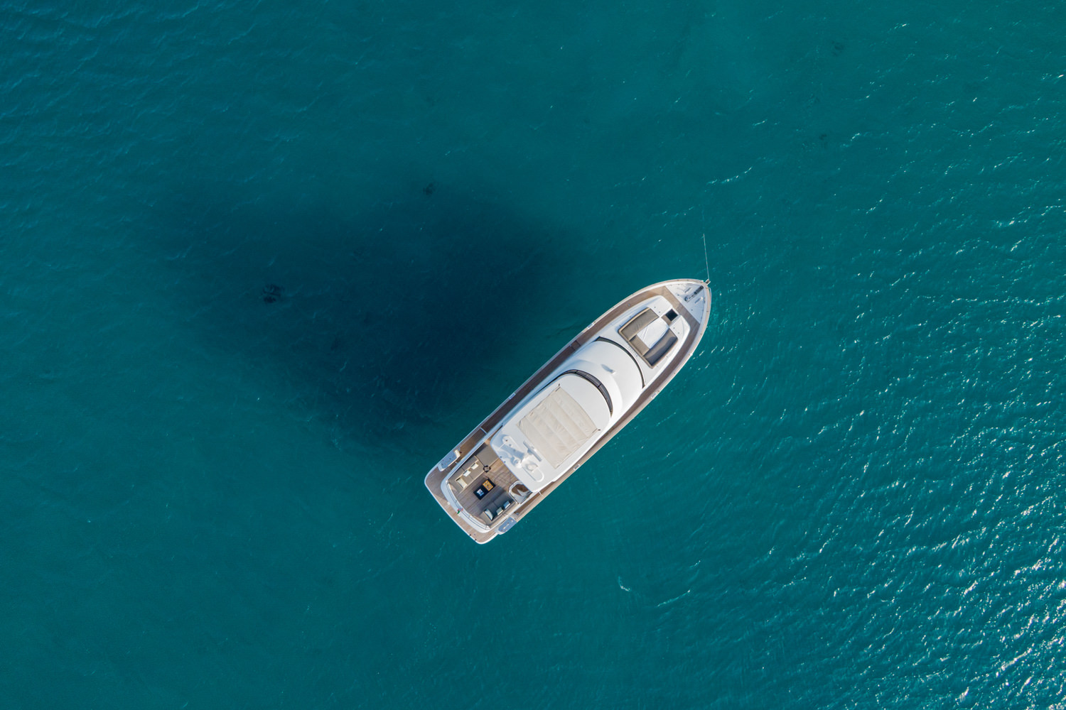 Aerial view of a luxury yacht cruising near La Spezia, with the Ligurian coast in the background.