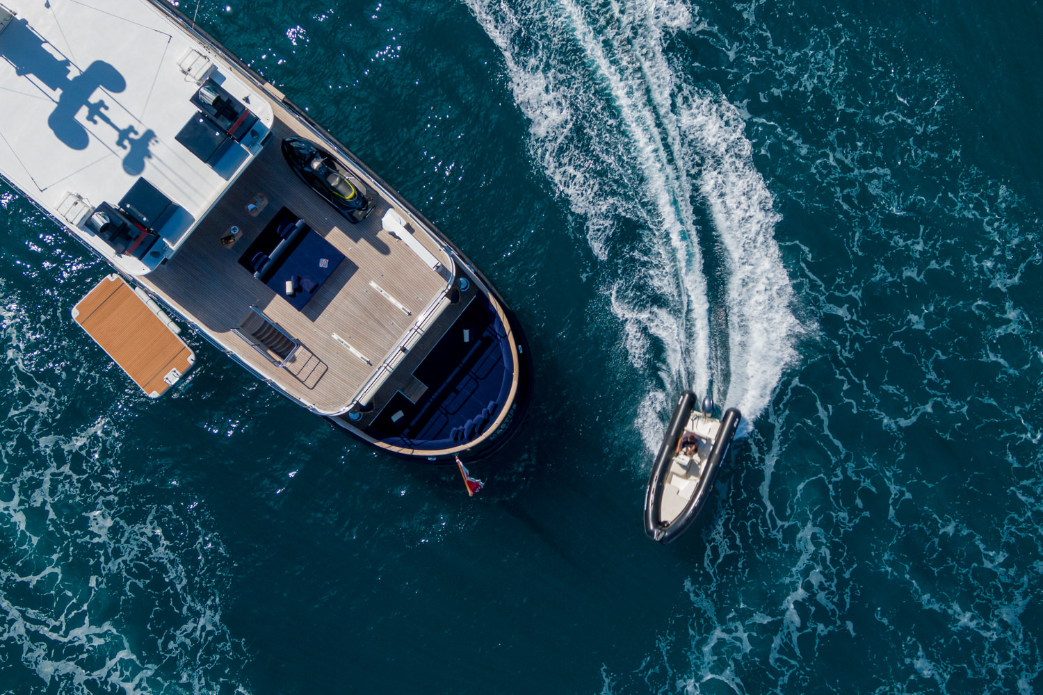 Aerial photograph of a luxury yacht cruising near Loano, with the Ligurian coast in the background.