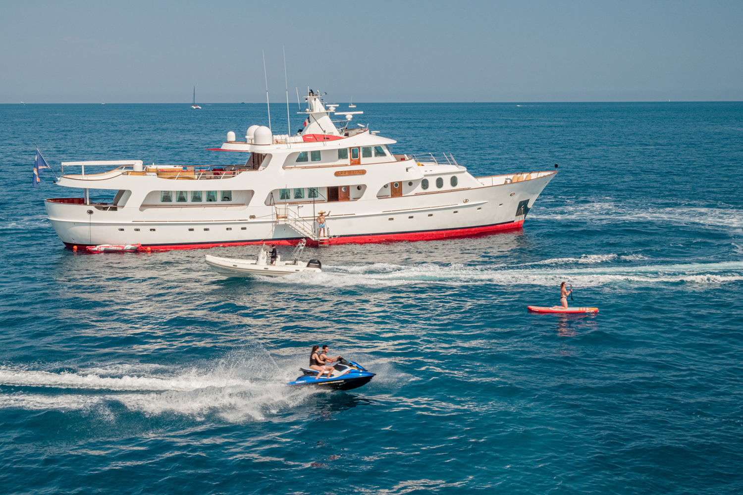 Aerial photograph of a luxury yacht sailing near Civitavecchia, with the Mediterranean coastline in the background.