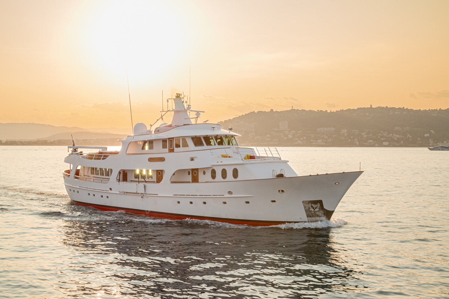 Aerial photograph of a luxury yacht cruising near Sanremo, with the Italian Riviera coastline in the background.