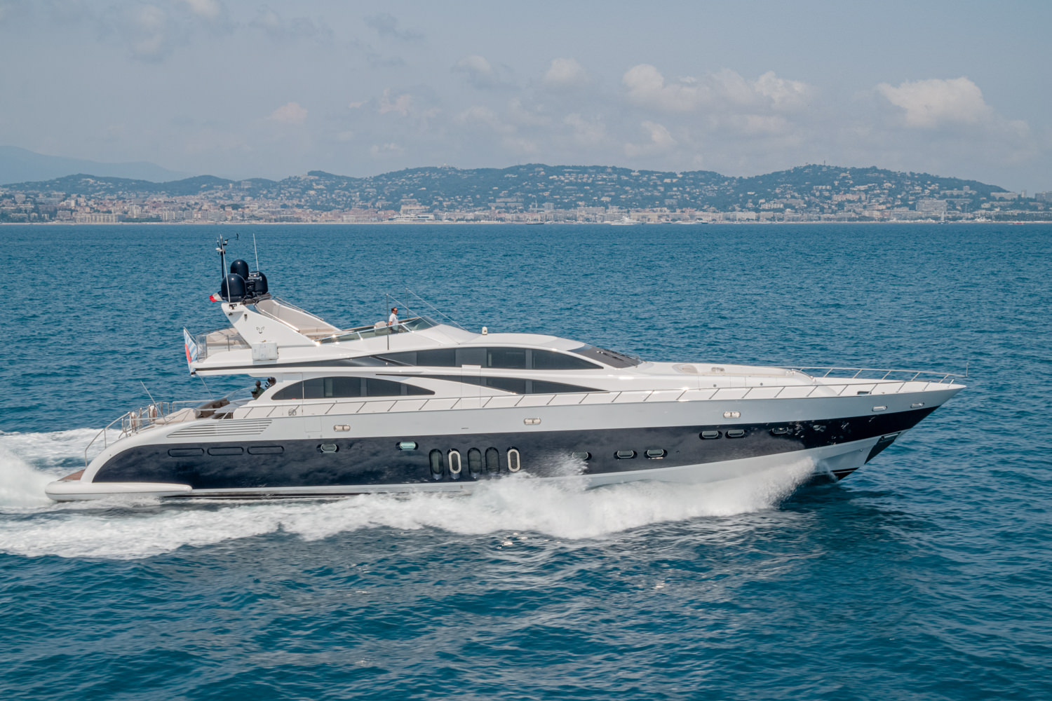 Drone shot of a luxury yacht anchored near Imperia, showcasing its elegant design against the Mediterranean backdrop.