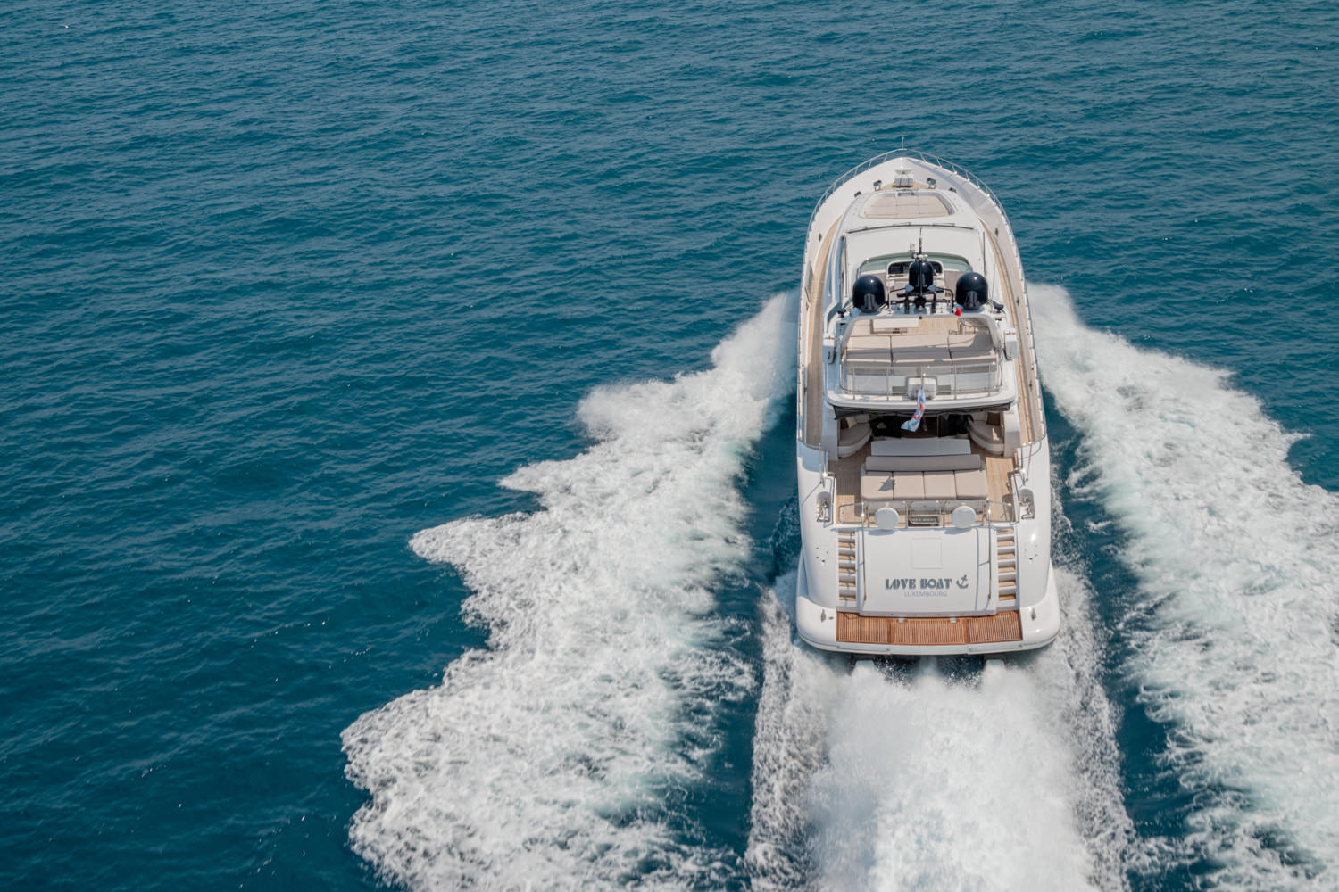 Drone shot of a luxury yacht anchored near Imperia, showcasing its elegant design against the Mediterranean backdrop.
