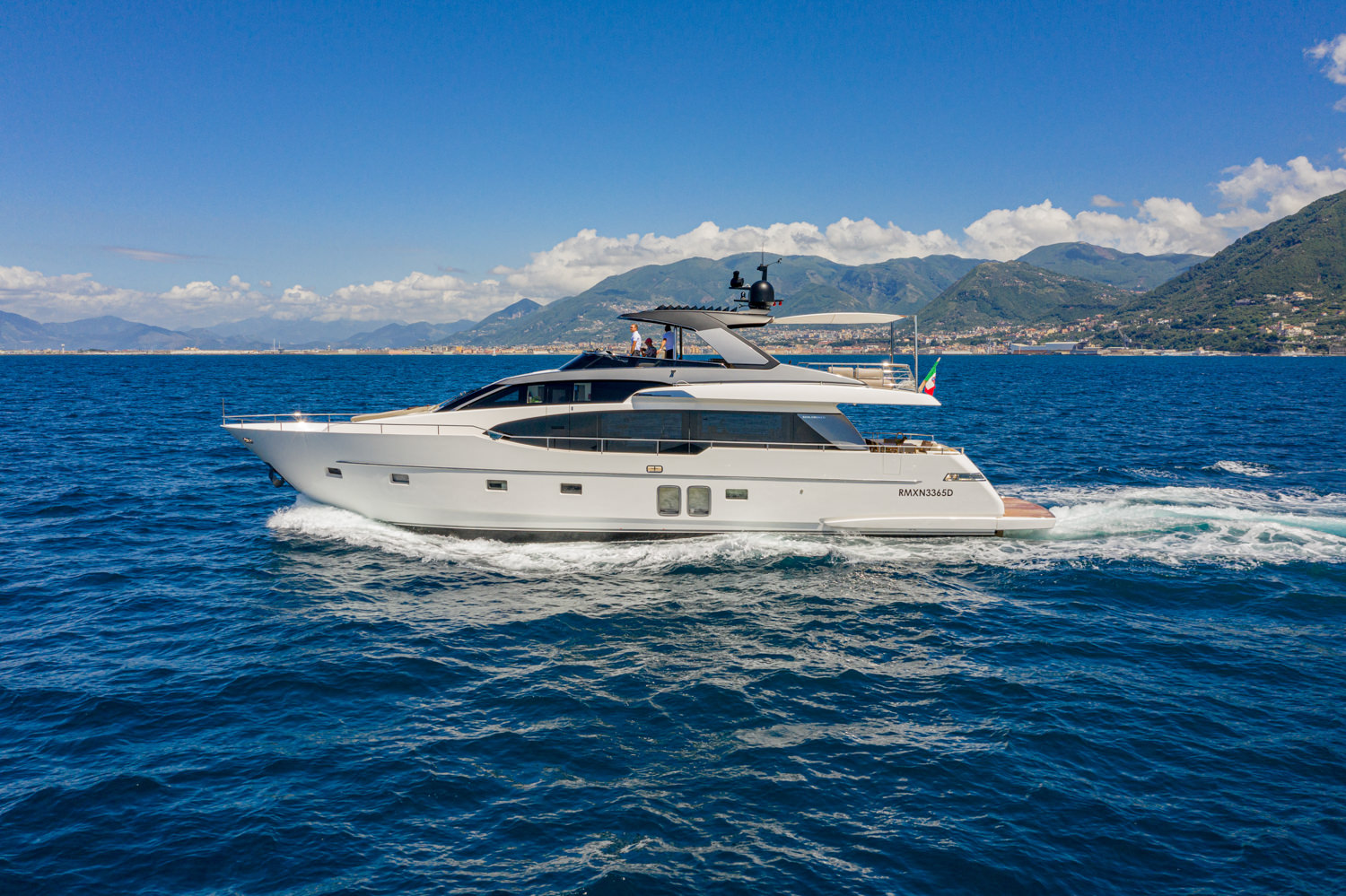 Drone view of a luxury yacht cruising near Antibes, with the beautiful coastline in the background.