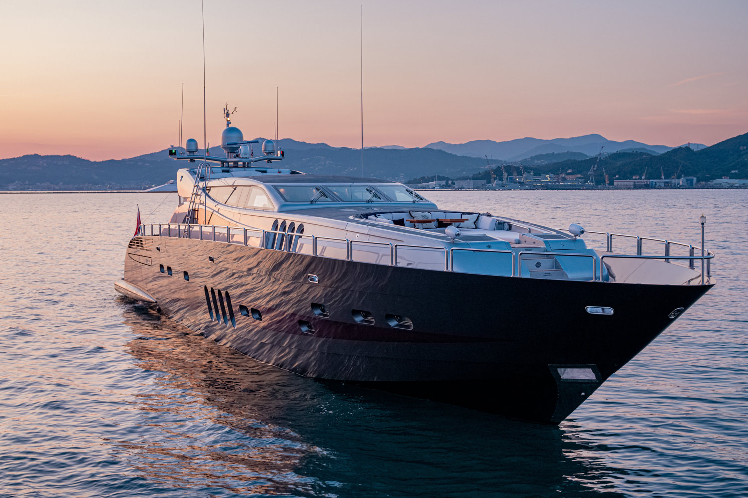 Drone image of a luxury yacht cruising near La Spezia, with a scenic coastal backdrop.
