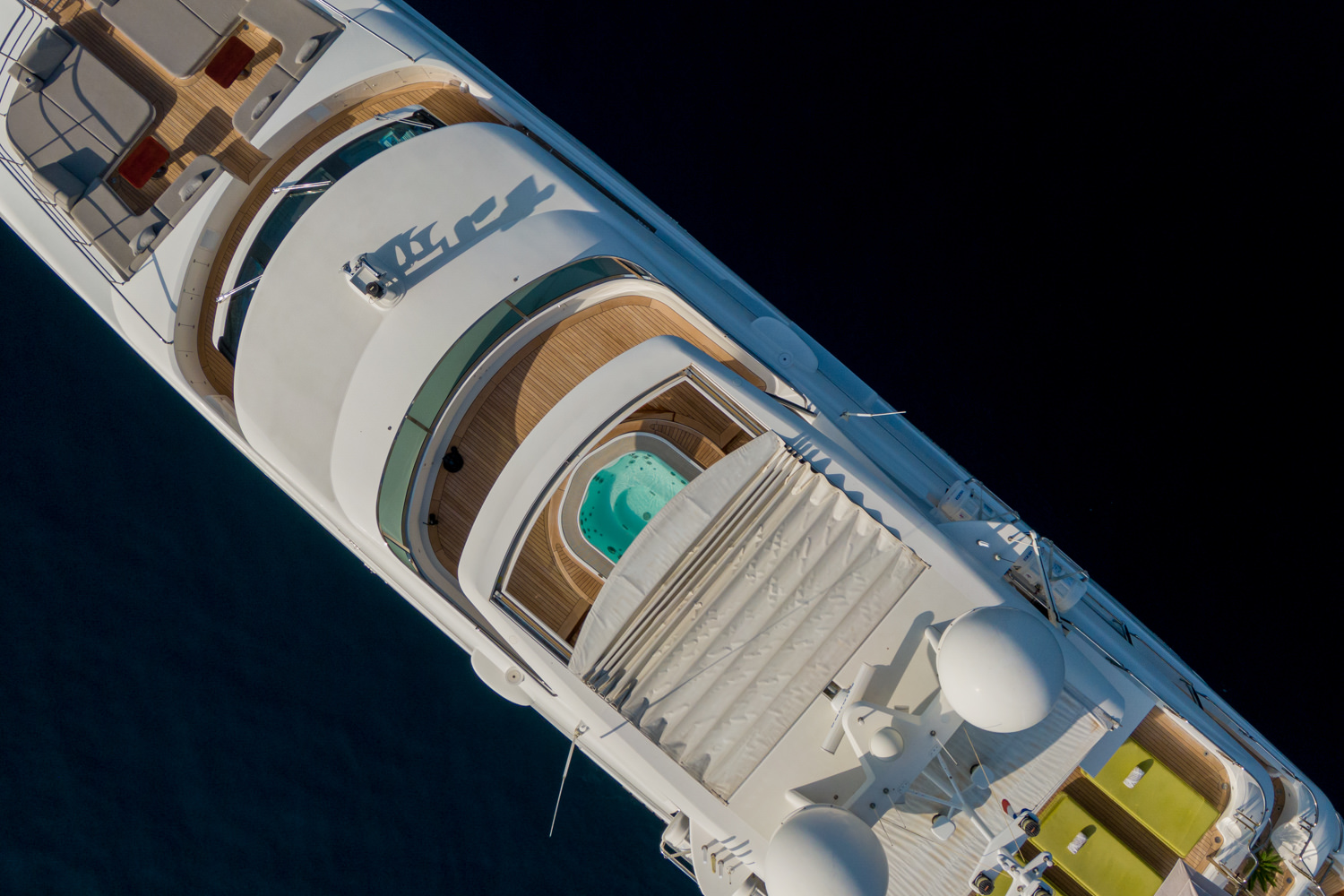 Drone photograph of a luxury yacht cruising along the coast near Livorno, highlighting its sleek design.