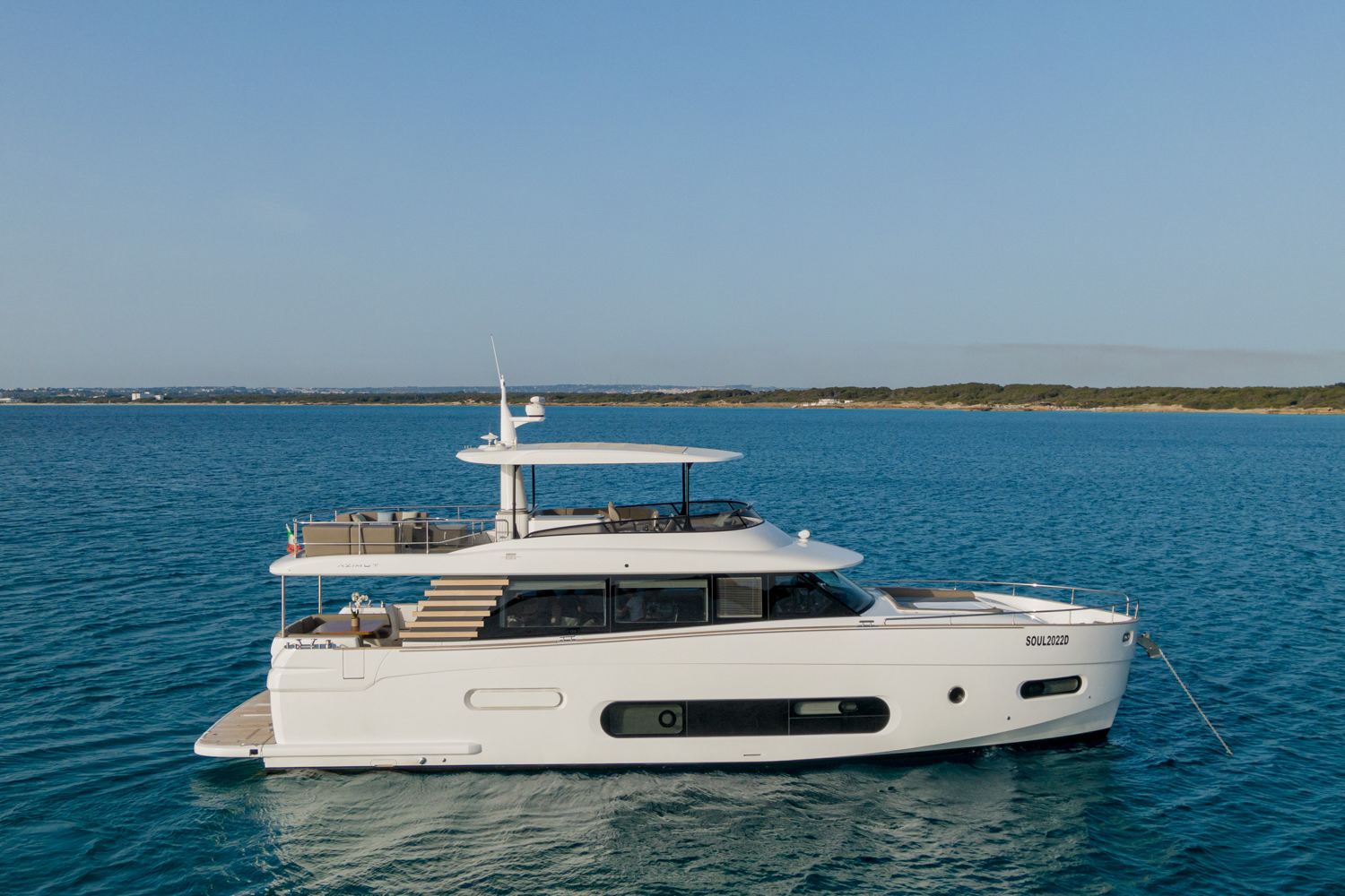 Drone shot of a luxury yacht anchored near Civitavecchia, with the Mediterranean coastline in the background.