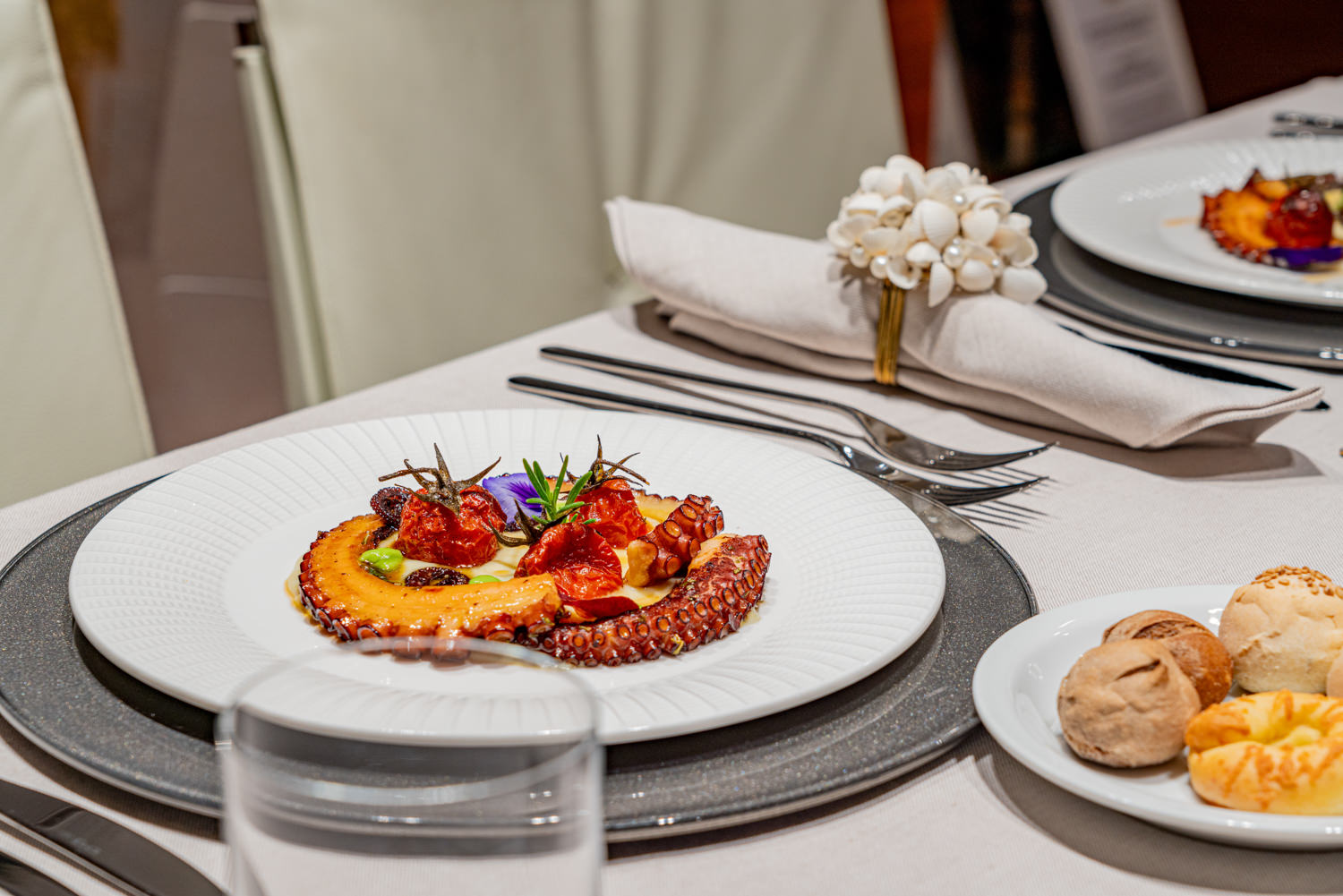 Gourmet octopus dish served aboard a luxury yacht, photographed in Naples.