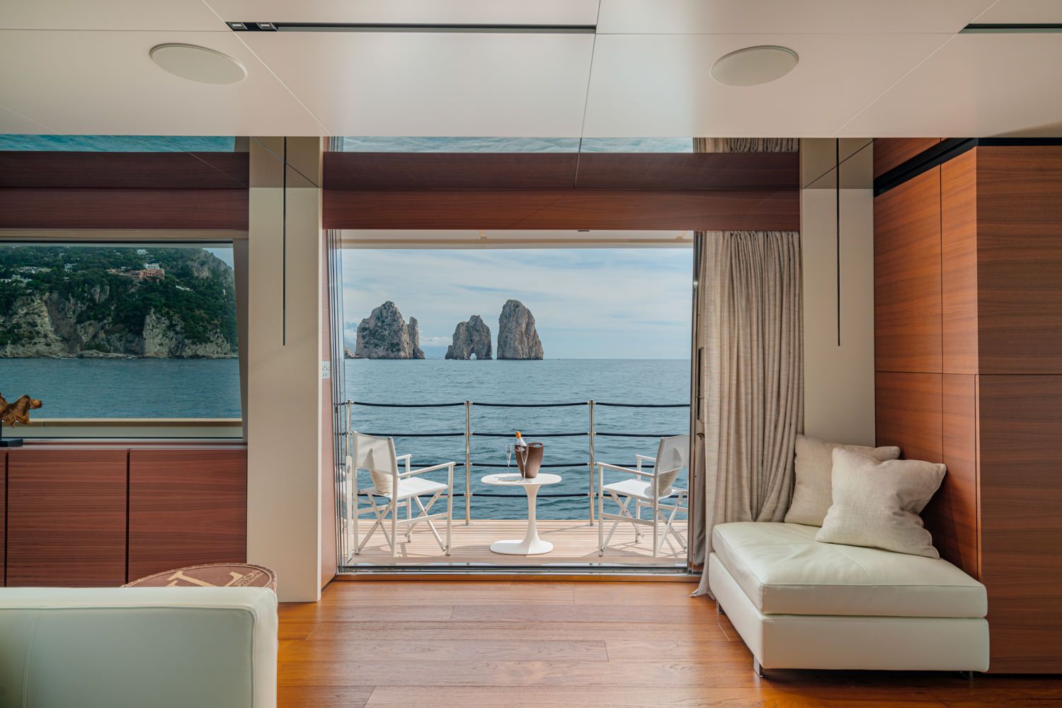 Main salon aboard a Ferretti yacht, photographed near the Faraglioni of Capri.