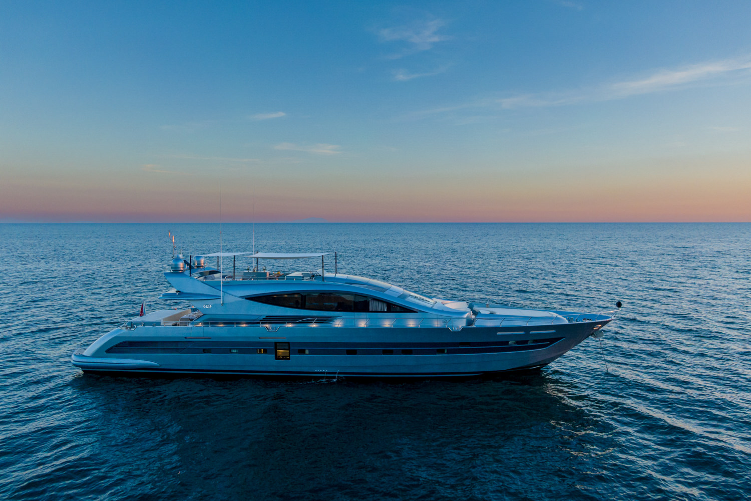 Drone image of a luxury yacht cruising near Antibes with a scenic Mediterranean view.