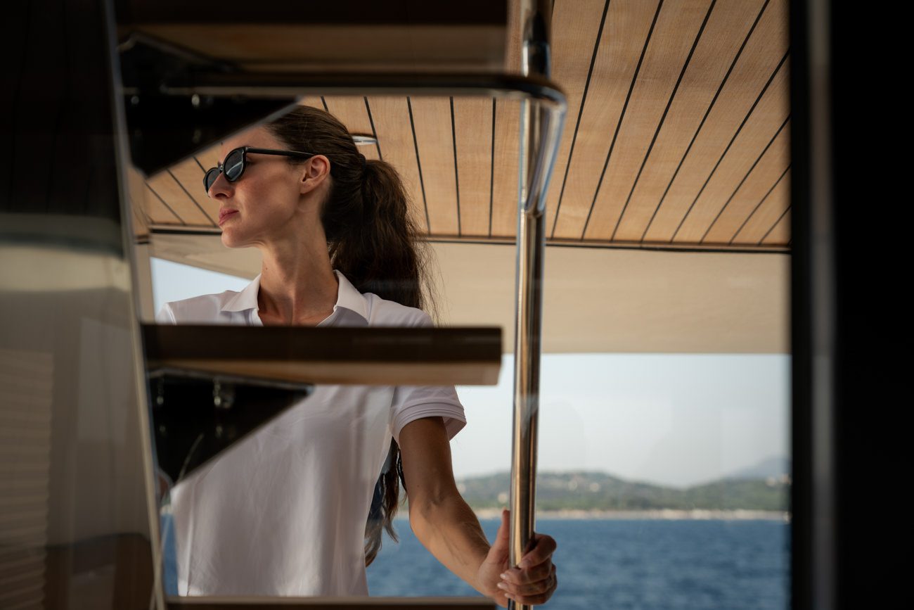 Un mannequin en maillot de bain tenant un équipement nautique lors d'une séance photo lifestyle à bord d'un yacht.