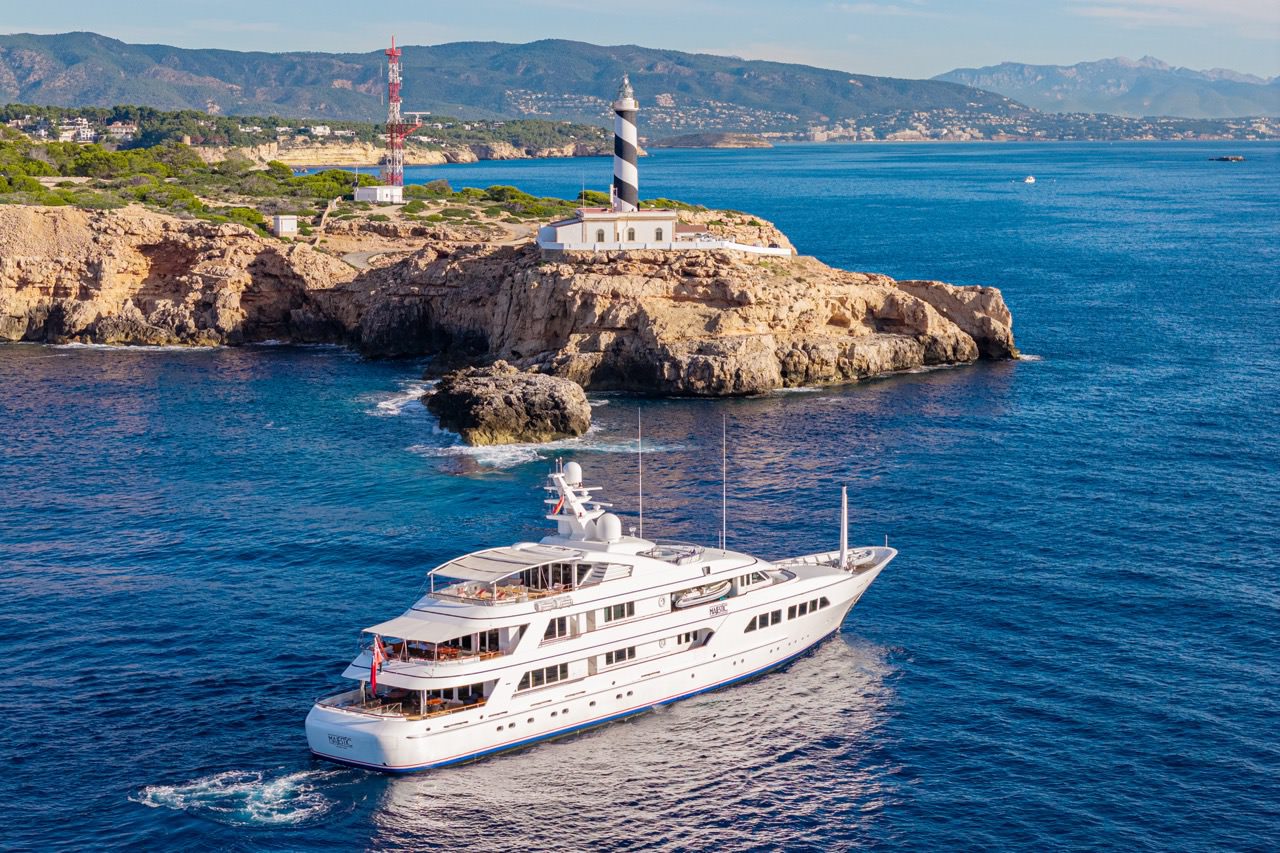 Drone photograph of a 64-metre Feadship yacht cruising along the rocky coast of Mallorca near Palma de Mallorca